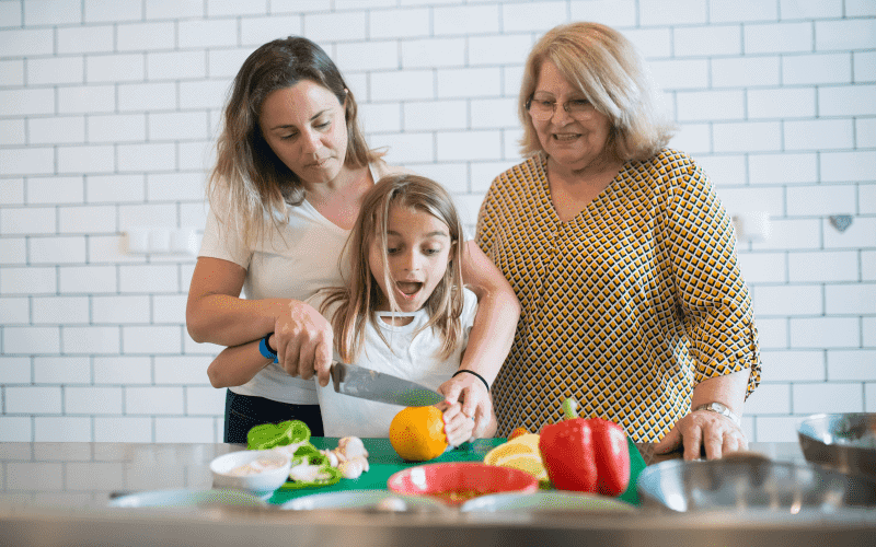 Grandma, mom, and child in kitchen looking at recipes